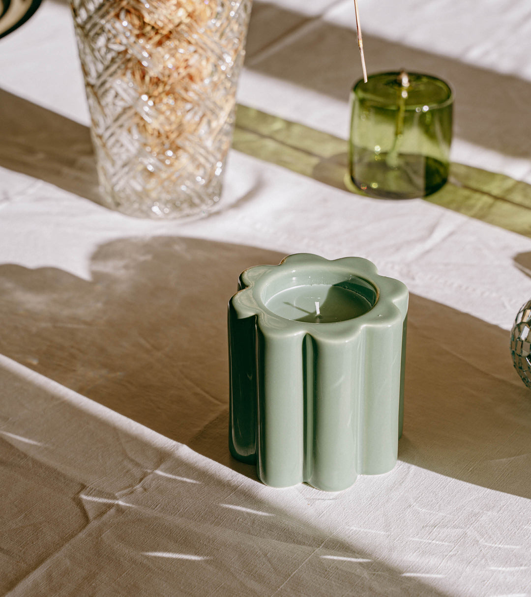 The Socialite Family Candela orange blossom scented candle in a green ceramic vessel, 240g, styled in a room setting